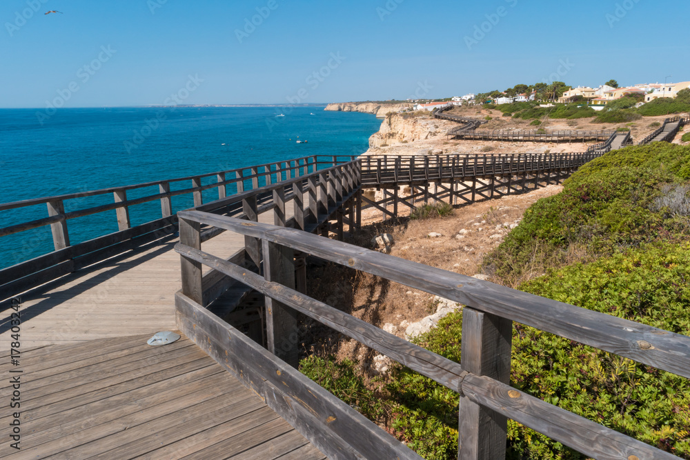 Obraz premium Wooden walkway to beautiful Carvoeiro beach with cliff and rock formation Algarve region Portugal