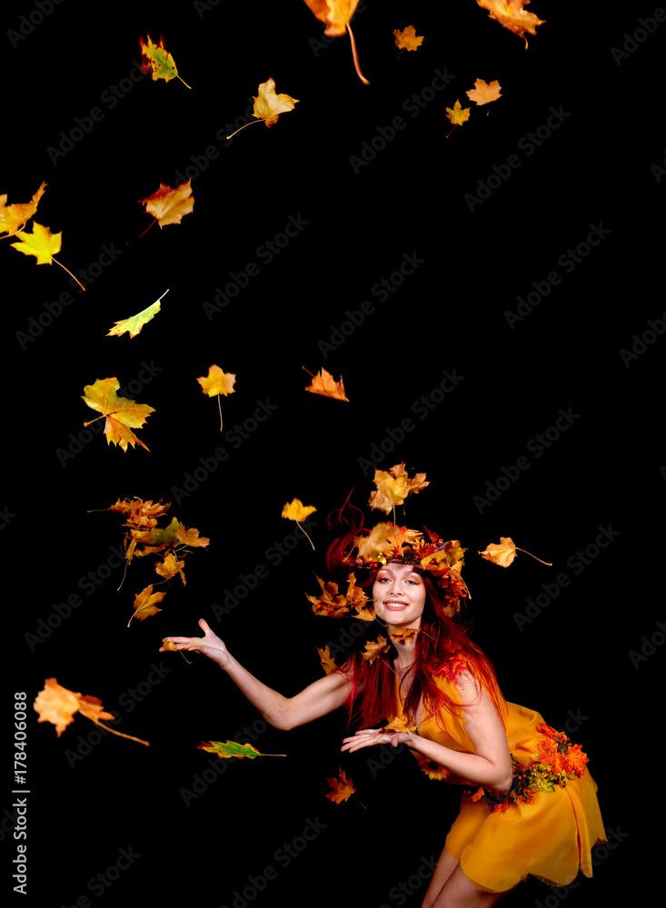 A beautiful young woman dresses up as an Autumn fairy and wears a wreath on her head made out of Autumn leaves. She poses for the camera while Autumn leaves fly around her. A beautiful young woman dresses up as an Autumn fairy and wears a wreath on her head made out of Autumn leaves. She poses for the camera while Autumn leaves fly around her.