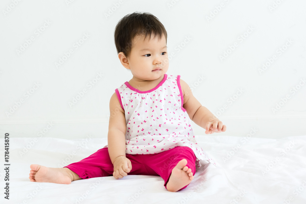 Portrait of adorable baby girl sitting on the bed Portrait of adorable baby girl sitting on the bed