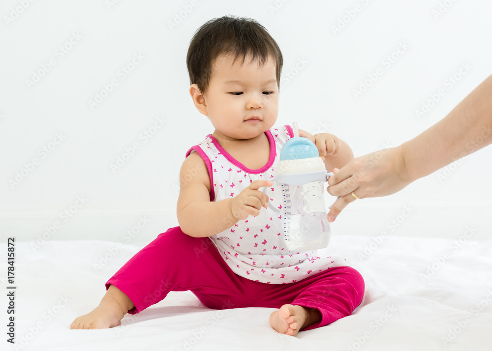 Portrait of adorable ibaby girl with a bottle of water, indoors Portrait of adorable ibaby girl with a bottle of water, indoors
