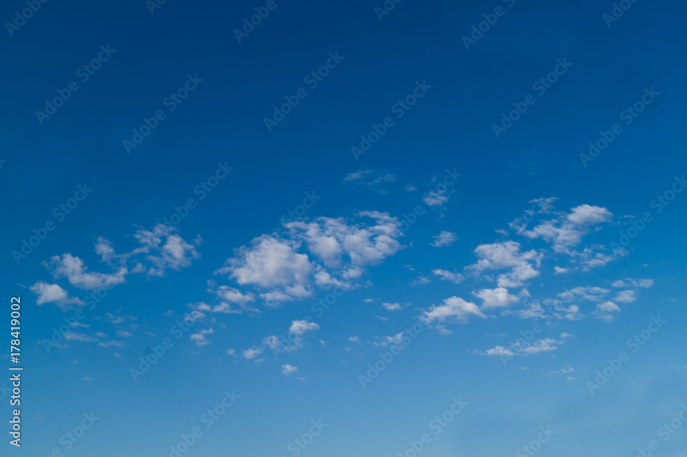 Three white fkuffy small clouds on the light-blue sky Three white fkuffy small clouds on the light-blue sky