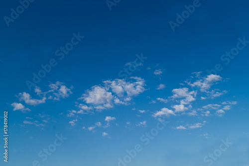 Three white fkuffy small clouds on the light-blue sky