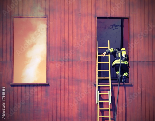 firefighter with a long ladder with the mask and the oxygen cyli photo