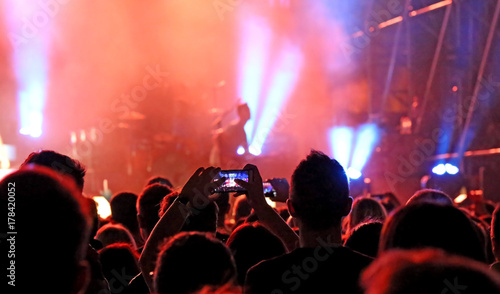 many people with modern smartphones during the live concert of a photo