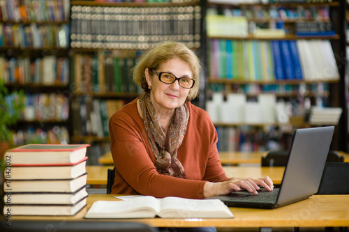 Fotografija Senior woman reading book in library