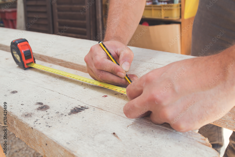 Carpenter working on raw wood / boards / plank. Carpenter working on raw wood / boards / plank.