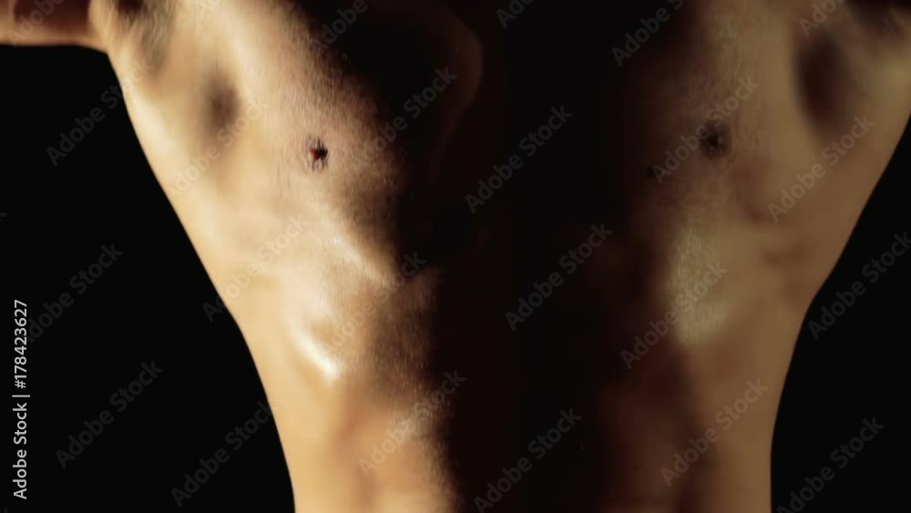 Close-up of portrait of strong athlete shows his torso. Slowly Close-up of portrait of strong athlete shows his torso. Slowly