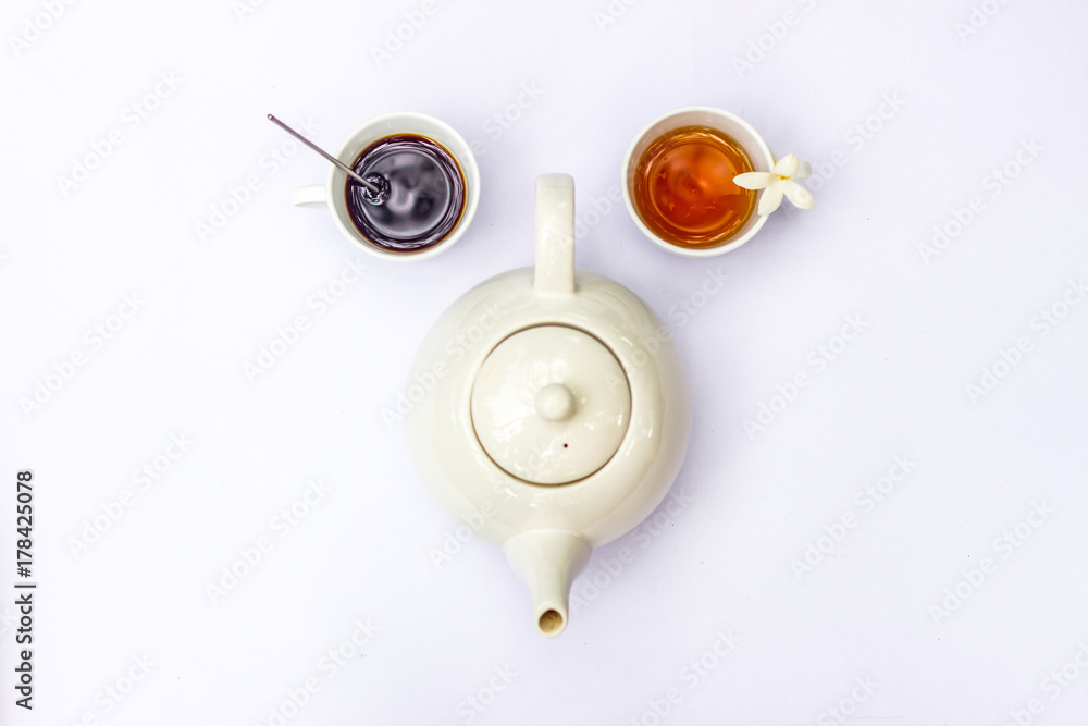 Top view of creative composition on cup of coffee, tea and white teapot on white background. In form of human funny parody face.