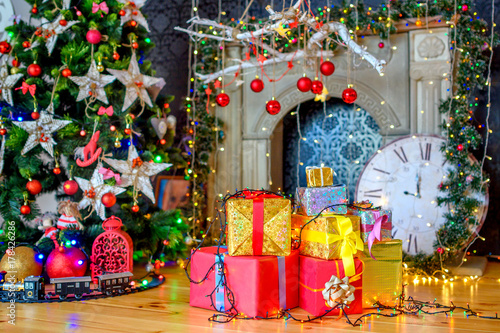 Obraz na płótnie Christmas background, a lot of boxes with gifts lies near the festive Christmas tree, in the background bright lights. w salonie
