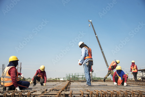 workers hands using steel wire and pincers to secure rebar before concrete is pour over it Construction site worker photo