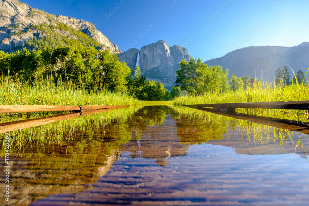 Meadow with flooded boardwalk and Yosemite Falls