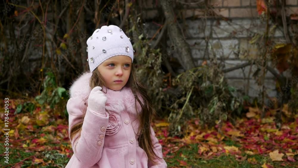baby girl lying on autumn leaves in pink coat and hat baby girl lying on autumn leaves in pink coat and hat