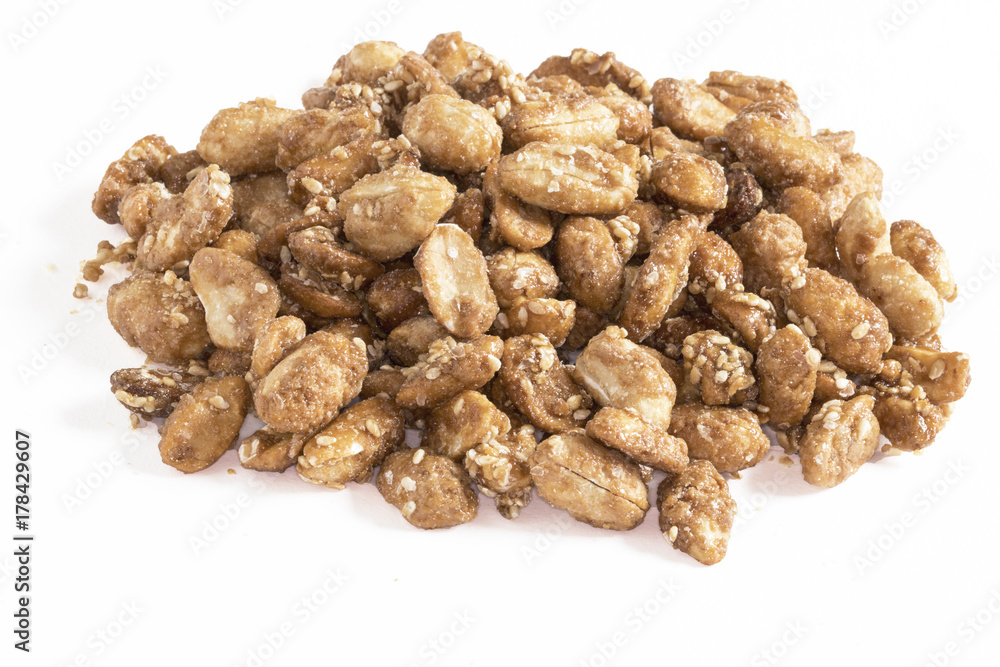 Cacahuètes sucrées en tas sur fond blanc Cacahuètes sucrées en tas sur fond blanc