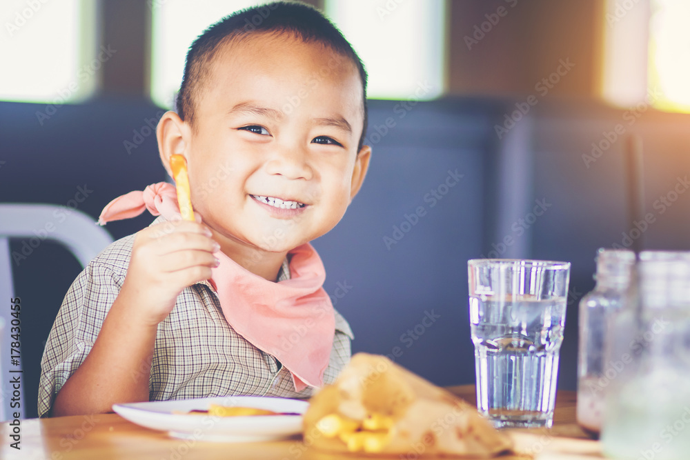 little boy enjoy eating french fries with his hands little boy enjoy eating french fries with his hands