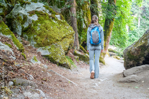 Tourist with backpack hiking on trail in Yosemite