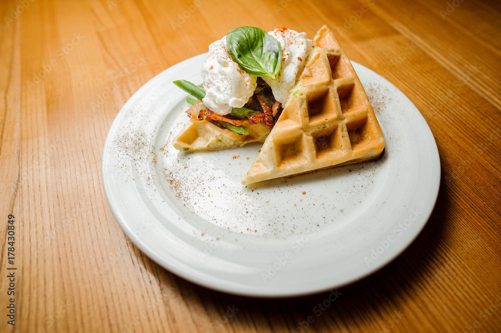 White plate with delicious waffle and vegetables