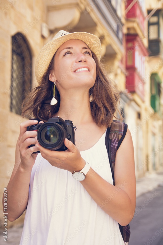 Young woman tourist with camera sightseeing in Valletta, Malta