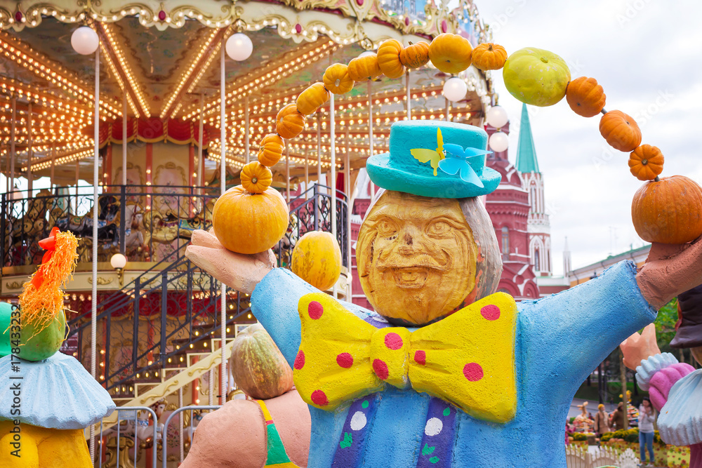 Fototapeta premium Juggler circus with pumpkins against the backdrop of a merry-go-round, halloween