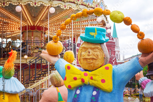 Juggler circus with pumpkins against the backdrop of a merry-go-round, halloween