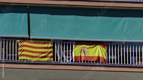 Photos The national flag of Spain and the flag of Catalonia are hung out together on the balcony of the building in Catalonia as a symbol of friendship and unity of the province and the state of Spain