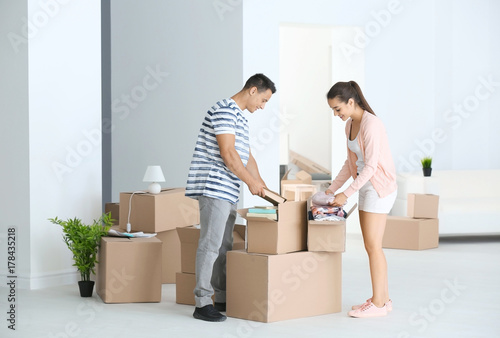 Young couple unpacking boxes in their new apartment