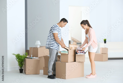 Young couple unpacking boxe...