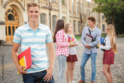 Young male student with fri...