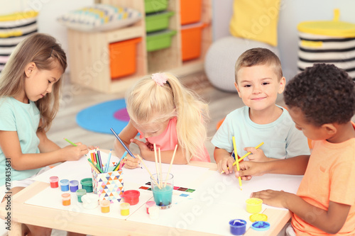 Cute children painting at table indoor