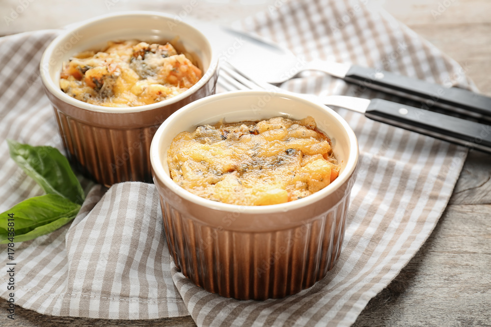 Ramekins with delicious sausage casserole on table Ramekins with delicious sausage casserole on table