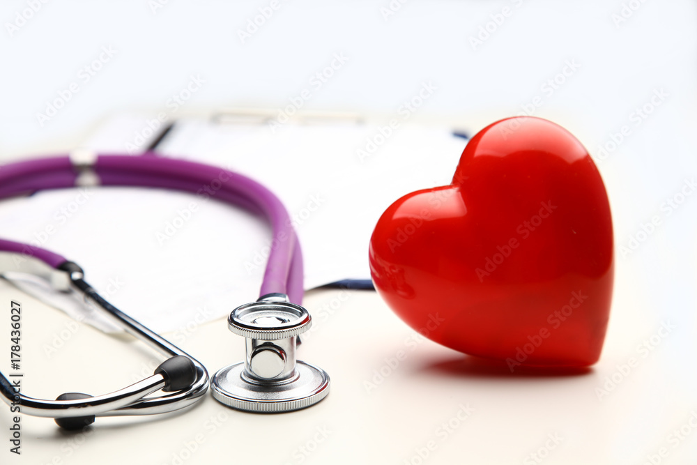 Heart with a medical stethoscope, isolated on wooden background Heart with a medical stethoscope, isolated on wooden background