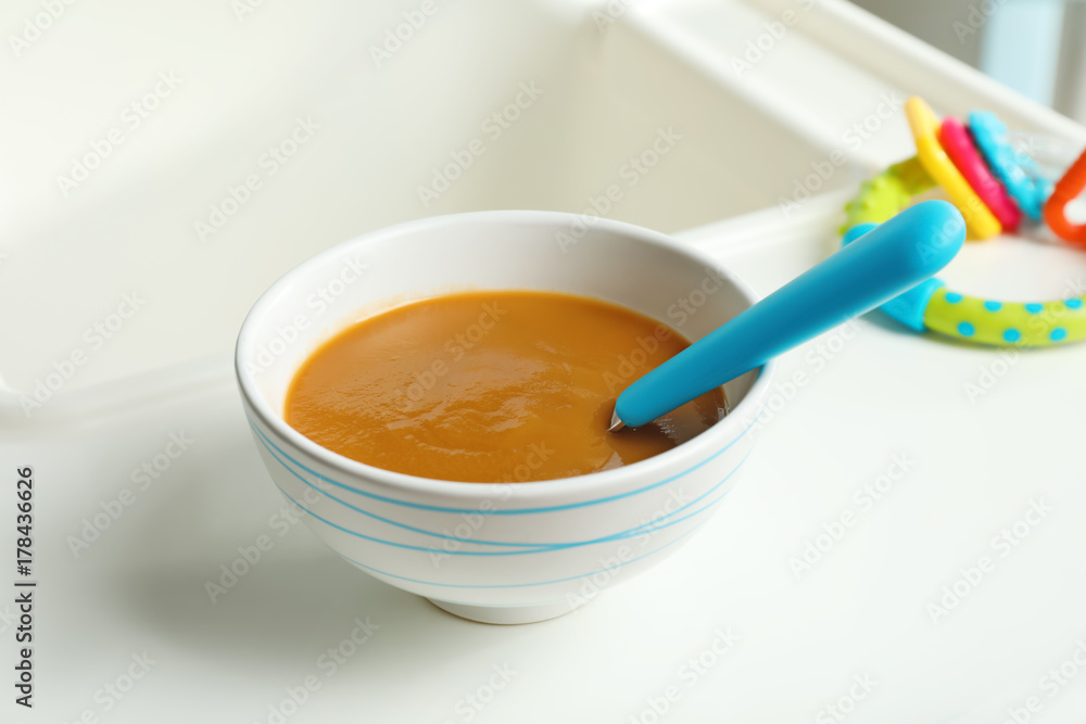 Bowl with baby food on highchair Bowl with baby food on highchair