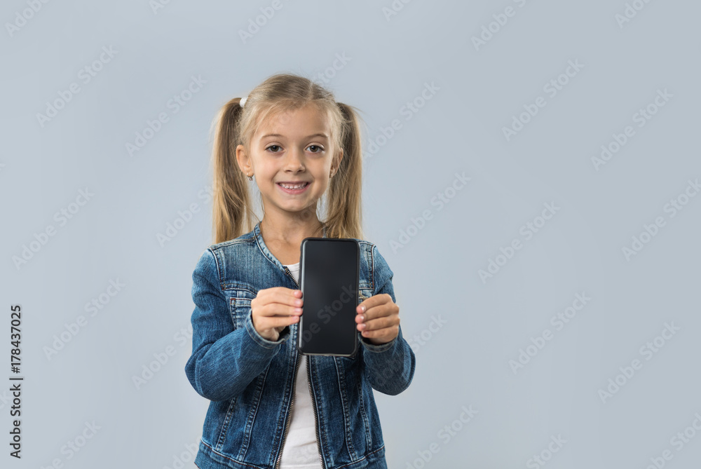 Beautiful Little Girl Hold Cell Smart Phone Empty Screen Happy Smiling Wear Jeans Coat Isolated Over Gray Background Beautiful Little Girl Hold Cell Smart Phone Empty Screen Happy Smiling Wear Jeans Coat Isolated Over Gray Background