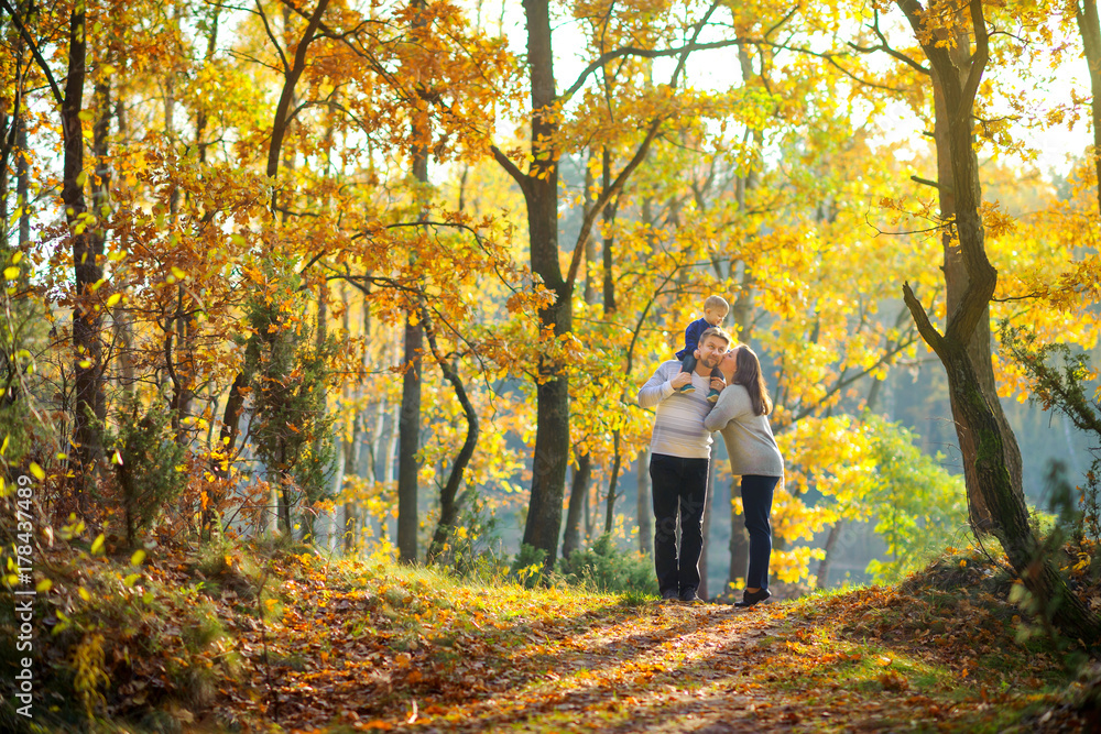 happy family walking in beautiful autumn park at sunset. happy family walking in beautiful autumn park at sunset.