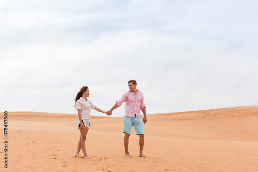 Young Man Woman Walking In Desert Couple Girl And Man Hold Hands Sand Dune Landscape Nature Background Young Man Woman Walking In Desert Couple Girl And Man Hold Hands Sand Dune Landscape Nature Background