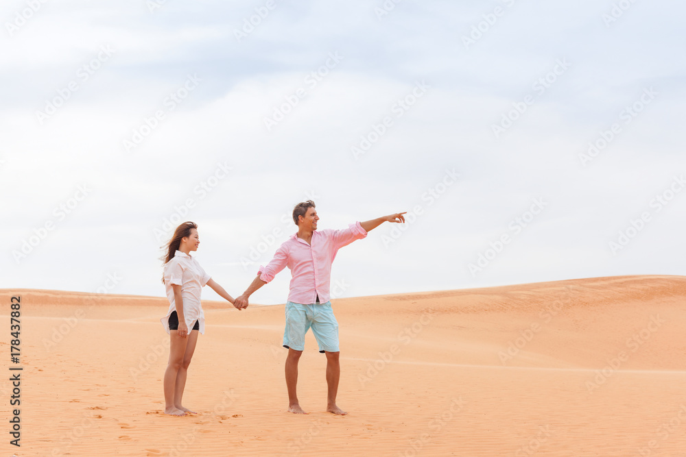 Young Man Woman In Desert Beautiful Couple Asian Girl And Guy Point Finger Sand Dune Landscape Background
