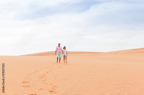 Young Man Woman Walking In Desert Couple Girl And Man Hold Hands Sand Dune Landscape Nature Background