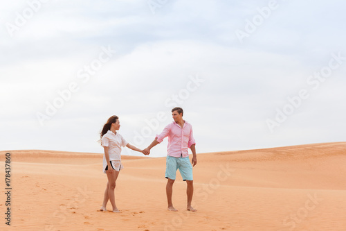Young Man Woman Walking In Desert Couple Girl And Man Hold Hands Sand Dune Landscape Nature Background