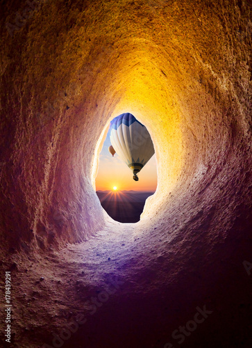 Hot air balloons at sunrise for your travel concept - view from the cave window in Cappadocia.