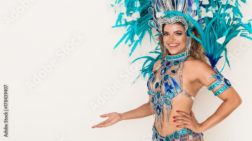 Beautiful brazilian samba dancer portrait smiling and showing something - Copy space