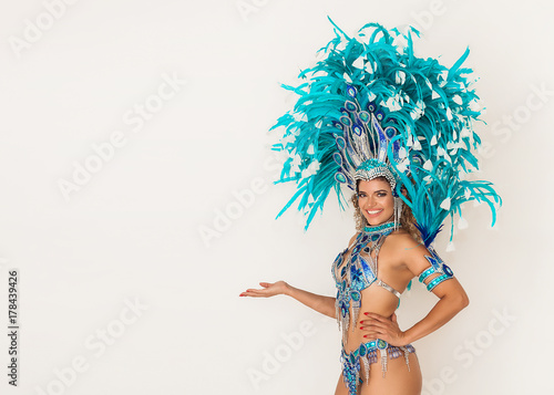 Beautiful brazilian samba dancer smiling and showing something - Copy space