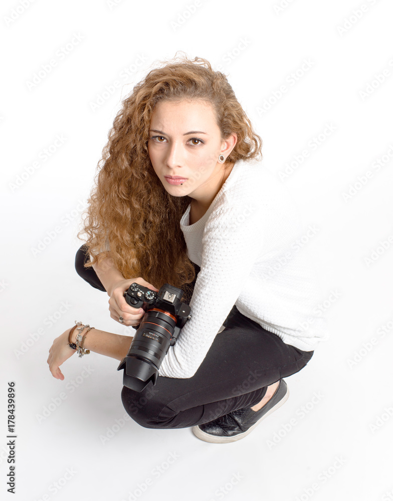 Fototapeta premium young girl with photo camera sitting on white background