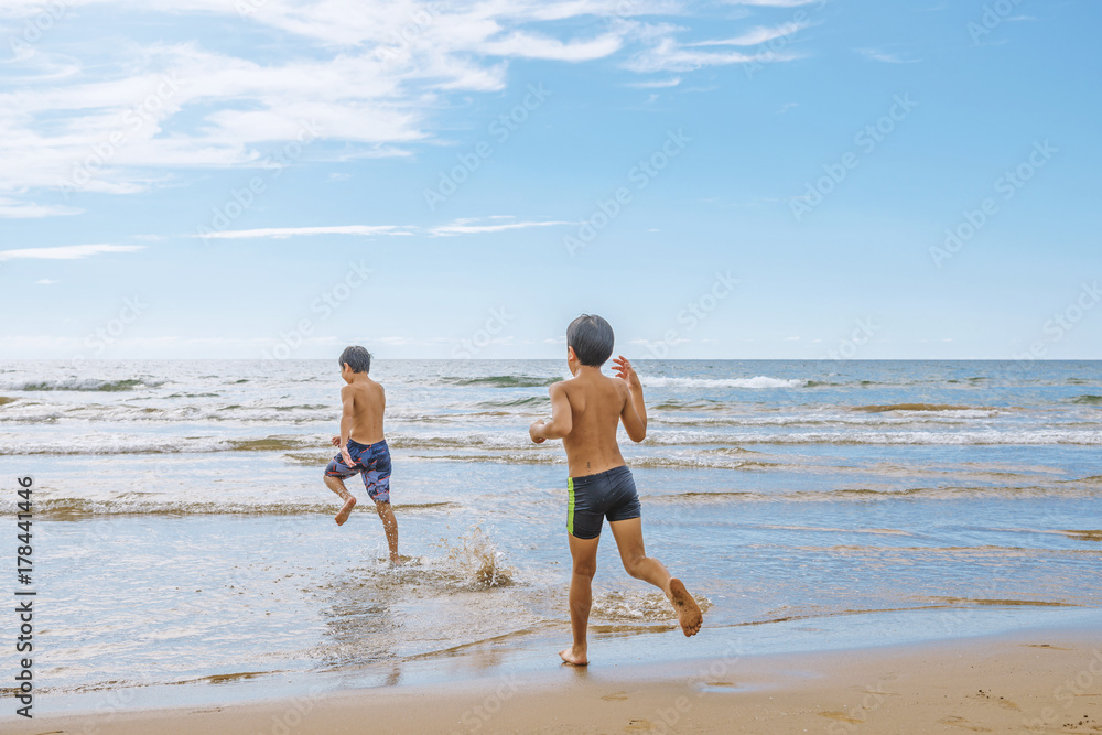 波打ち際で戯れる少年たち