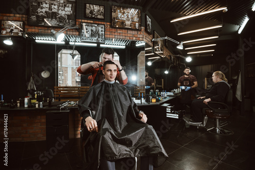at hairdresser/ Barber cutting in barbershop. Working day at the hairdresser