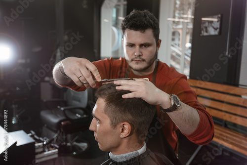 short haircut/ Barber cutting in barbershop. Barber fingers measure the length of the hair
