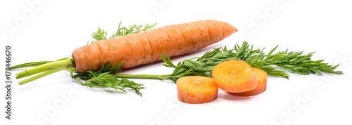 Group of sliced round orange carrot circles with fresh green leaf and one whole carrot isolated on white background