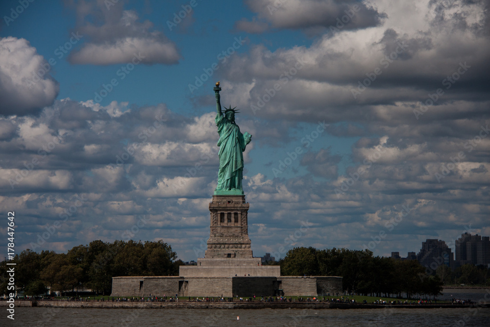 Postcard from New York: Statue of Liberty against cloudy sky on sunny day, Liberty Island