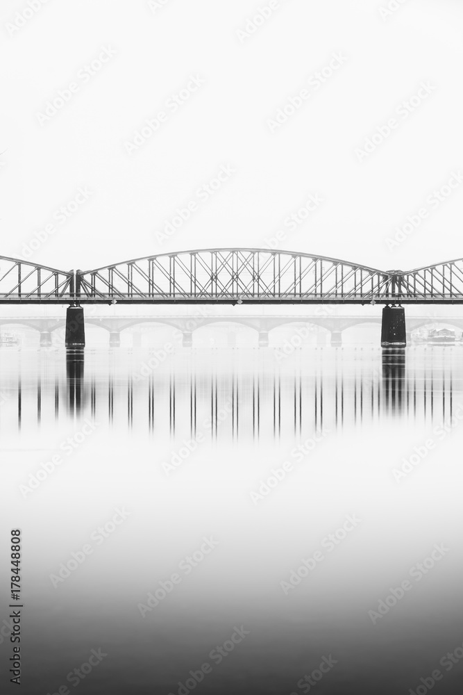 Naklejka premium Foggy winter mood at Vltava river. Reflection of bridges in water. Black and white atmosphere, Prague, Czech republic