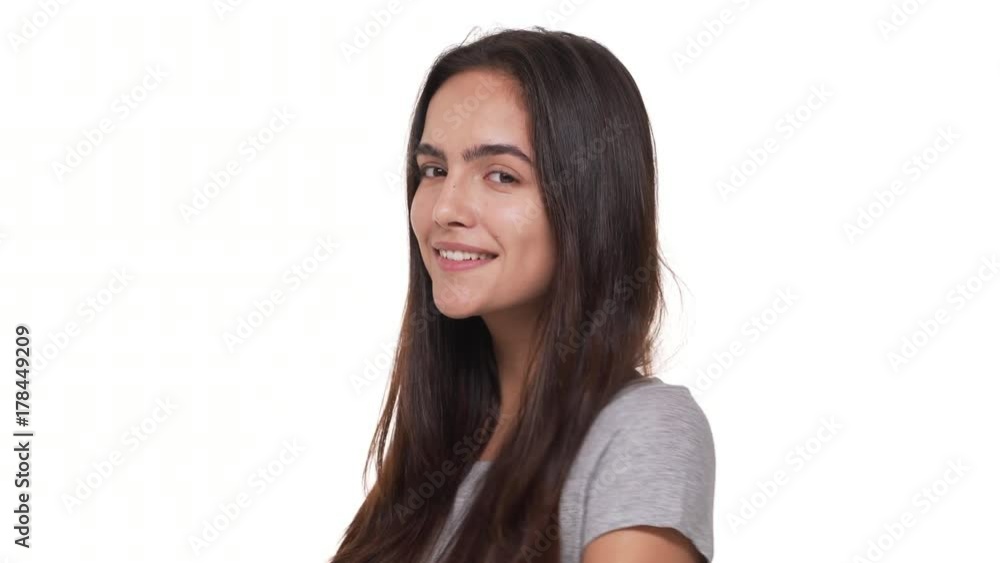 portrait of flirting cute woman with long dark hair playfully looking at camera smiling winking over white background closeup. Concept of emotions portrait of flirting cute woman with long dark hair playfully looking at camera smiling winking over white background closeup. Concept of emotions