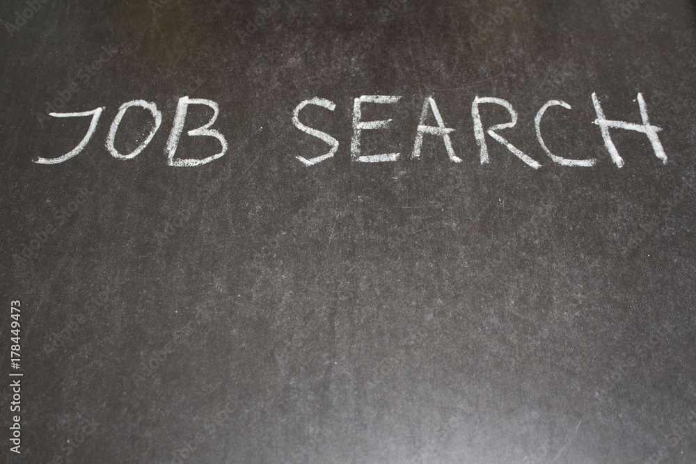 Fototapeta premium JOB search message hand written on the blackboard with white chalk. Copy space for text . Banner for job search.