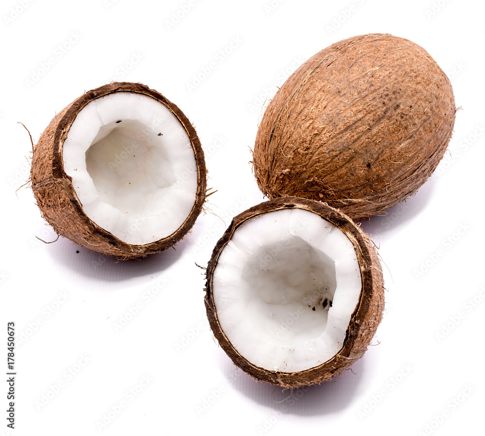 One whole and two cracked coconut halves isolated on white background